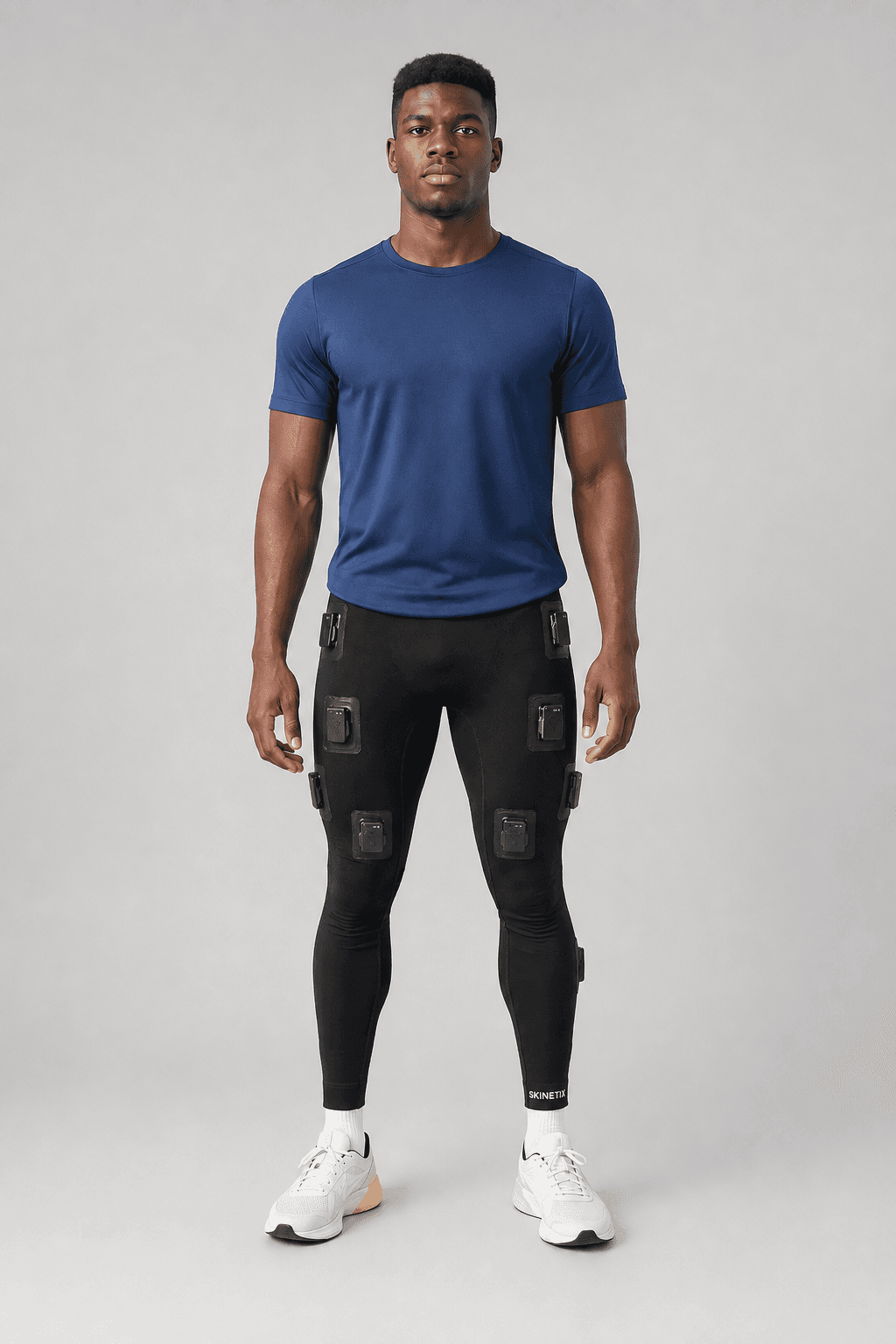 Full-body studio photograph of the Skinetix sensor-integrated leggings worn by an athlete, showing the sensor module placements.